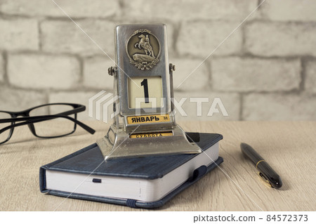 Retro manual desk calendar with date of first day of new year 1 January on desk Retro manual desk calendar with date of first day of new year 1 January on desk 84572373