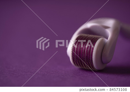 cosmetic face roller on purple background cosmetic face roller on purple background 84573108