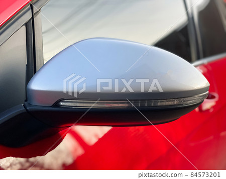Close-up car mirror for viewing the blind spots of a red car. Car details Close-up car mirror for viewing the blind spots of a red car. Car details 84573201