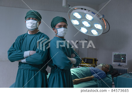 Dortor Professor Smiling surgeon crossing his arms while standing in a surgical room. 84573685