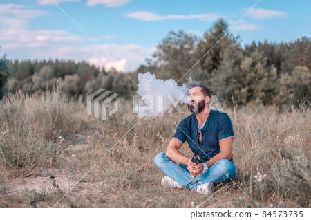 Modern man releases a cloud of steam. Health concept. 84573735
