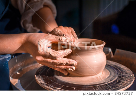 Young female potter working on a potter's wheel 84573737