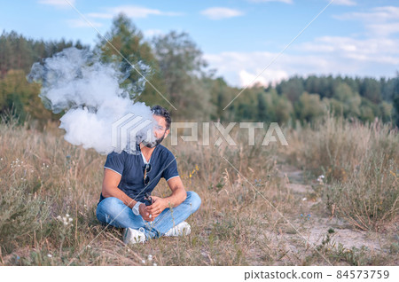 Stylish brutal vaper enjoying an vape on the ground. Vaping concept. 84573759
