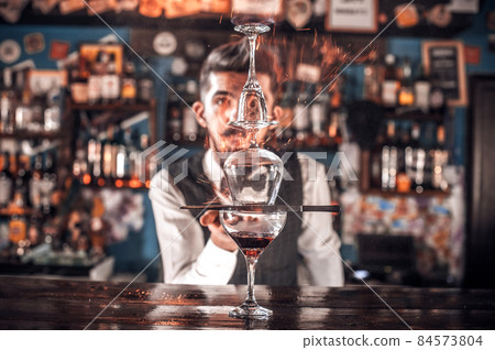 Experienced bartender adds ingredients to a cocktail in cocktail bars Experienced bartender adds ingredients to a cocktail in cocktail bars 84573804