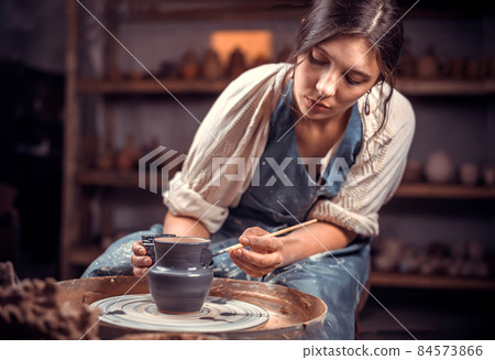Beautiful ceramist making ceramic pot on the pottery wheel . Handiwork. Beautiful ceramist making ceramic pot on the pottery wheel . Handiwork. 84573866
