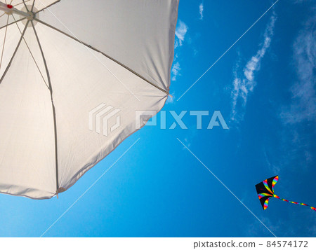 Kite sky. Colorful high flying toy. Air kite fly on blue wind background. Rainbow kite in summer clouds. Concept of dreams, freedom, childhood. 84574172