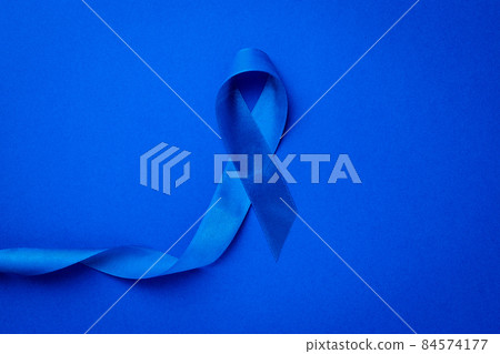 Cancer awareness blue. Awareness of men health in November with blue prostate cancer ribbon isolated on deep blue background. November and International Mens Day. Cancer awareness blue. Awareness of men health in November with blue prostate cancer ribbon isolated on deep blue background. November and International Mens Day. 84574177
