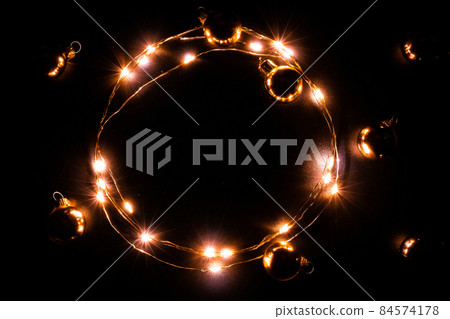 Christmas lights border. Golden light garland decoration, gold bulb isolated on black for xmas party ornament decor background. Glowing lights for Christmas Holiday. 84574178