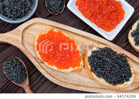 Sandwiches with black sturgeon and red salmon caviar close up Sandwiches with black sturgeon and red salmon caviar close up 84574209