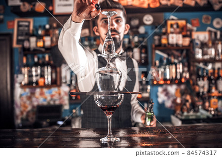 Bartender concocts a cocktail in the porterhouse 84574317