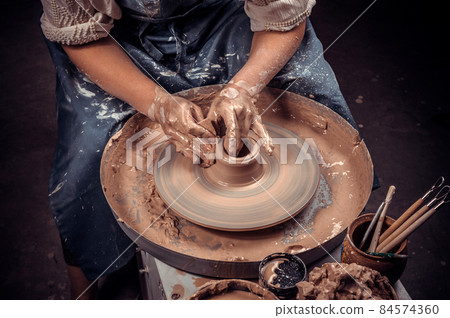Ceramist master is working on pottery wheel. Artisan production. Close-up. Ceramist master is working on pottery wheel. Artisan production. Close-up. 84574360