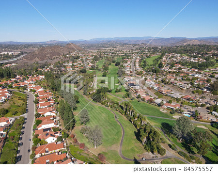 Aerial view of golf in residential neighborhood in an Diego County 84575557