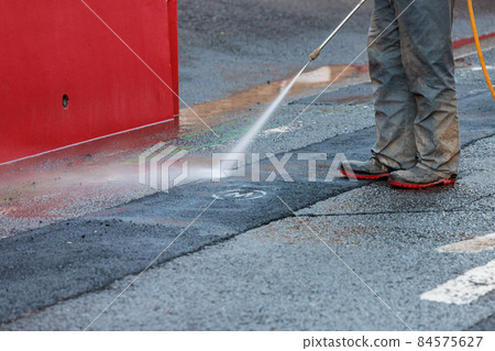 Workers cleaning dirty roads with high-pressure water during water pipe repair work Workers cleaning dirty roads with high-pressure water during water pipe repair work 84575627