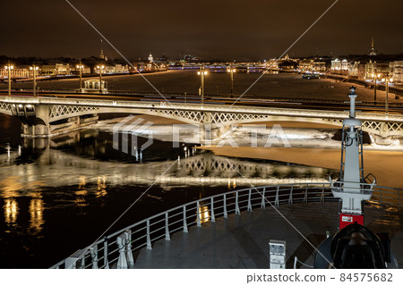 The panoramic view from cabin of ship of the winter night city Saint-Petersburg with picturesque reflection on water, big ship moored near Blagoveshchensky bridge or lieutenant Schmidt The panoramic view from cabin of ship of the winter night city Saint-Petersburg with picturesque reflection on water, big ship moored near Blagoveshchensky bridge or lieutenant Schmidt 84575682