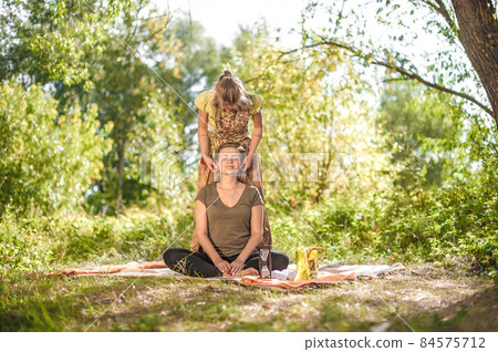 Experienced masseuse gives her client a refreshing massage out in the forest. Experienced masseuse gives her client a refreshing massage out in the forest. 84575712