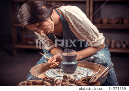 Charming female master working with pottery at the ceramic workshop. Handwork. Charming female master working with pottery at the ceramic workshop. Handwork. 84575889