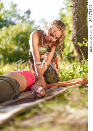 Massage professional impliments her massage abilities outside. Massage professional impliments her massage abilities outside. 84575891