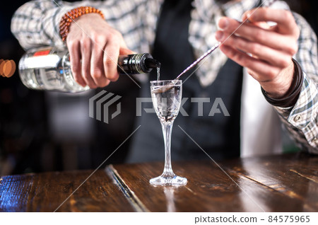 Barman formulates a cocktail in the bar Barman formulates a cocktail in the bar 84575965
