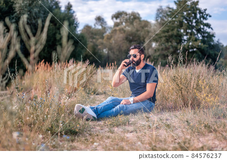Modern vaper with electronic cigarette in the outdoors. Health concept. Modern vaper with electronic cigarette in the outdoors. Health concept. 84576237
