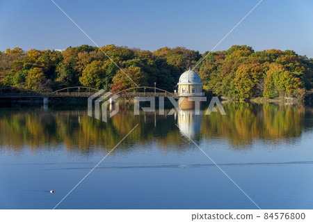 Lake Tama in autumn colors: Lake surface and second intake tower seen from above the embankment Lake Tama in autumn colors: Lake surface and second intake tower seen from above the embankment 84576800