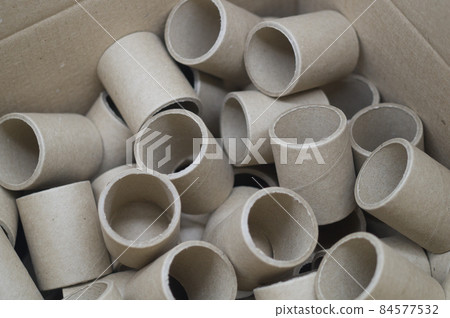 Cardboard spools in bulk in a box. Reels with a diameter of 40 mm for winding paper. Selective focus Cardboard spools in bulk in a box. Reels with a diameter of 40 mm for winding paper. Selective focus 84577532