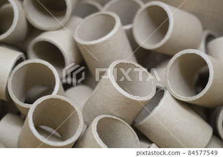 Empty cardboard spools in bulk in a box. Reels with a diameter of 40 mm for winding paper. Selective focus Empty cardboard spools in bulk in a box. Reels with a diameter of 40 mm for winding paper. Selective focus 84577549