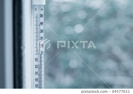 Sub-zero temperature on the thermometer outside the window. Winter. Selective focus. Sub-zero temperature on the thermometer outside the window. Winter. Selective focus. 84577631
