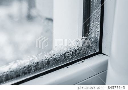 Defective plastic window with condensation formed on the glass. Detection of a lack of double-glazed windows. Selective focus 84577643