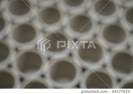 Abstract background. Cluster holes. Blurred cardboard sleeves. Defocused spools and bobbins for winding paper. Abstract background. Cluster holes. Blurred cardboard sleeves. Defocused spools and bobbins for winding paper. 84577659