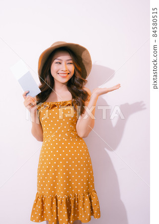 Travel concept portrait of smiling woman holding passport with ticket showing copy paste 84580515