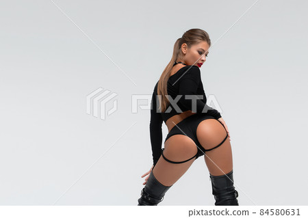 Alluring young woman in black underwear and boots 84580631