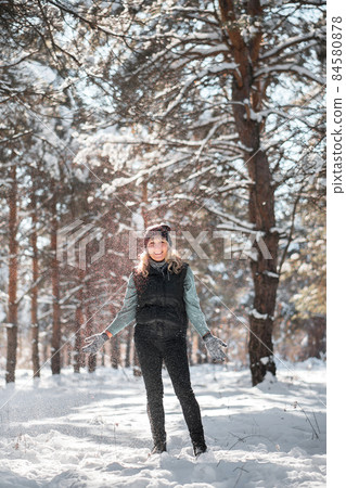 Woman stands in snowy forest. Woman stands in snowy forest. 84580878