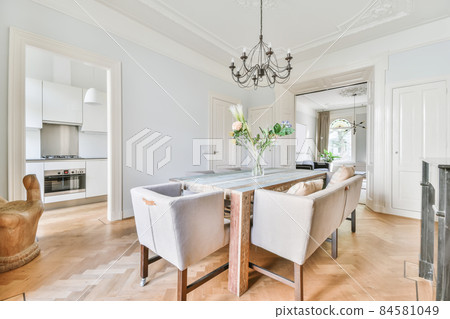 Elegant dining room with large table and comfortable soft chairs 84581049