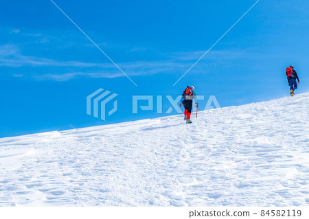 Climbers climbing snowy mountains and blue sky [Nagano Prefecture] 84582119