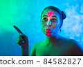 Portrait of woman in colorful neon lighting. 84582827