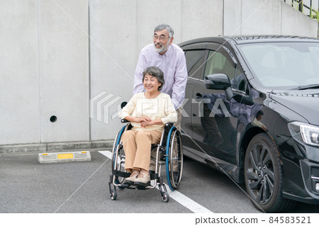 Senior couple wheelchair parking lot 84583521