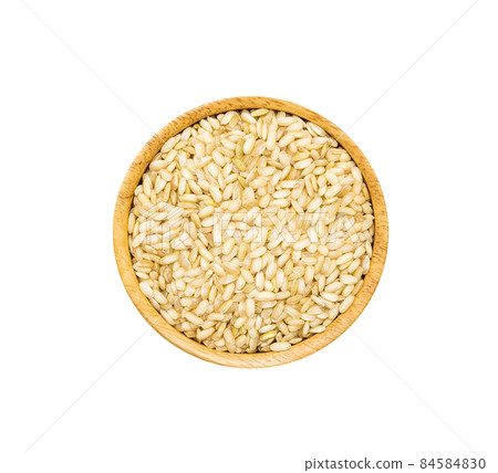 Organic brown rice in wooden bowl on white background, top view. 84584830