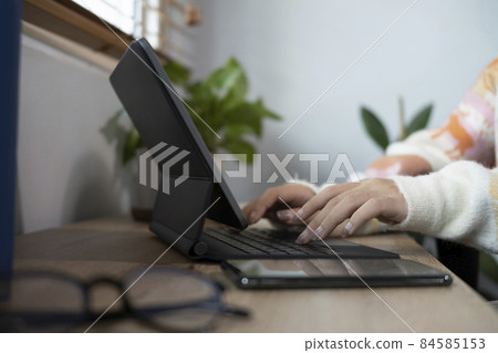 Close up young woman hands typing on wireless keyboard of digital tablet. 84585153