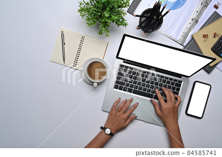 Overhead view businesswoman working with laptop on white office desk. 84585741