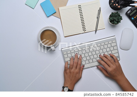 Above view woman sitting at her office desk and typing on keyboard. 84585742