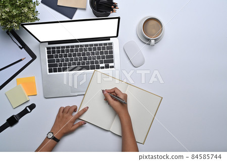 Businesswoman working with laptop and making notes on notebook. Businesswoman working with laptop and making notes on notebook. 84585744