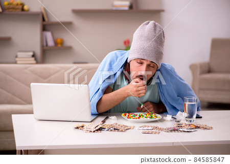 Young sick man suffering at home Young sick man suffering at home 84585847