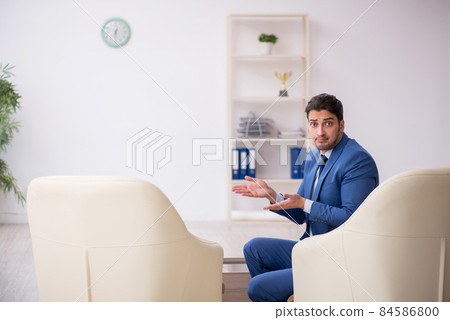 Young male employee waiting for business meeting Young male employee waiting for business meeting 84586800