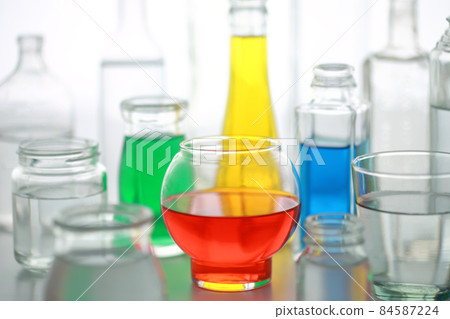 Bottles and cups of colored water Bottles and cups of colored water 84587224