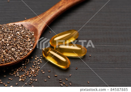 Organic natural chia seeds and wooden scoop close-up on wooden background or table Organic natural chia seeds and wooden scoop close-up on wooden background or table 84587885