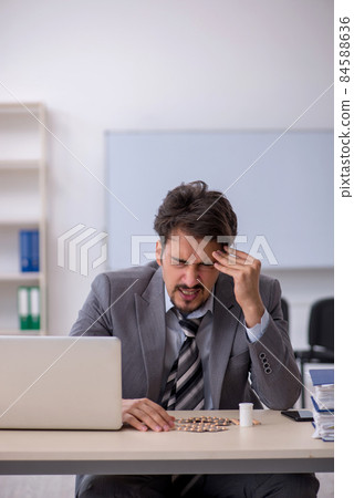 Young businessman employee suffering at workplace Young businessman employee suffering at workplace 84588636