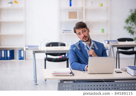 Young male employee working in the office Young male employee working in the office 84589115