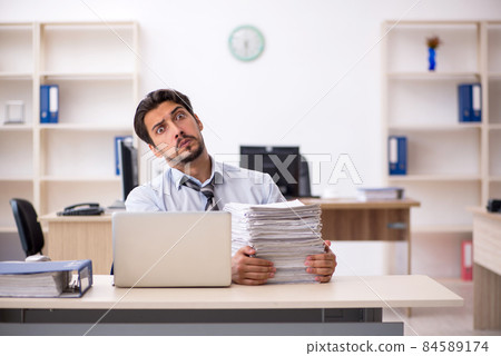 Young male employee working in the office Young male employee working in the office 84589174