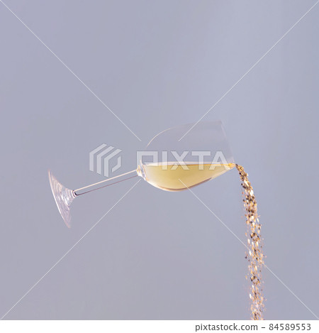Confetti comes out of a glass of wine against blue background. Confetti comes out of a glass of wine against blue background. 84589553