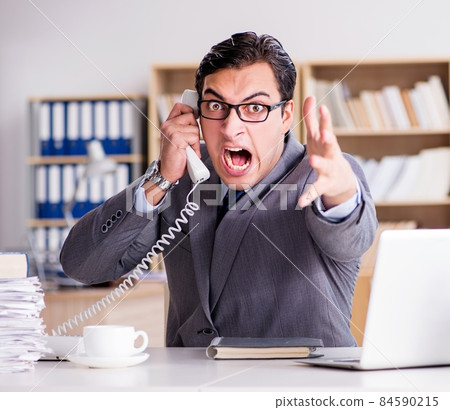 Angry businessman with too much work in office 84590215